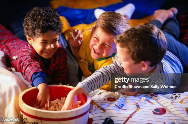 boys eating popcorn at slumber party - boys sleepover stock pictures, royalty-free photos & images