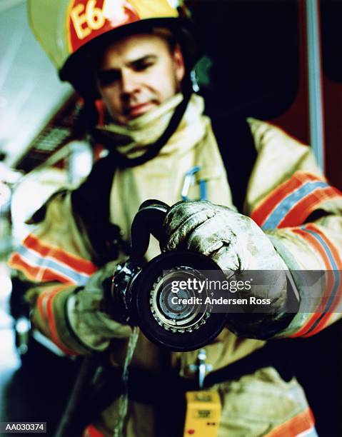 firefighter holding hose (focus on nozzle of hose) - emergency services equipment stock pictures, royalty-free photos & images