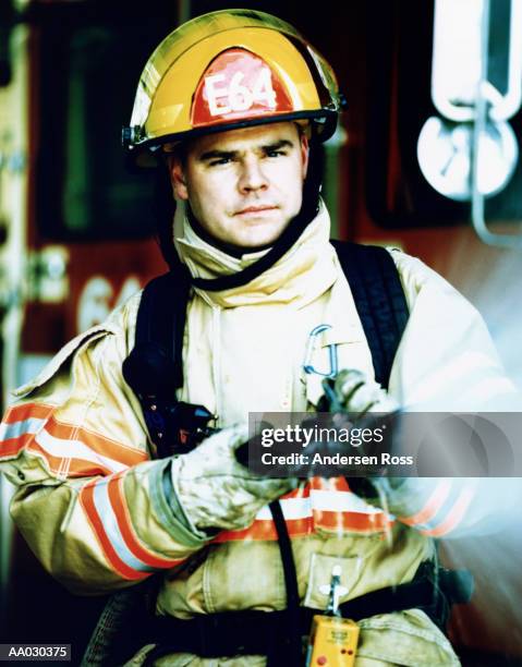 firefighter spraying hose, portrait, high section - noodapparatuur stockfoto's en -beelden