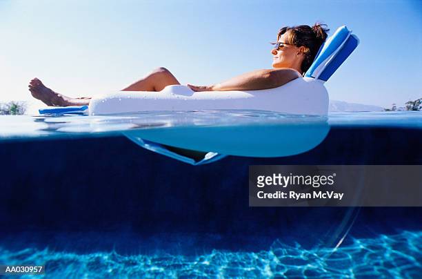 woman relaxing in a floating chair - hollister stockfoto's en -beelden