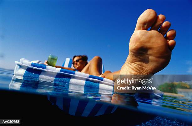 woman relaxing in a floating chair - woman soles stockfoto's en -beelden