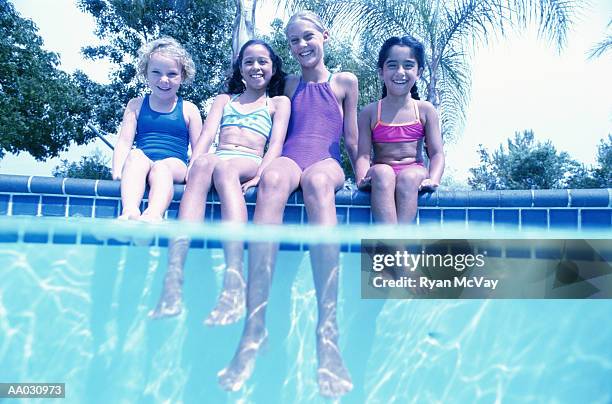 four girls sitting on the edge of a pool - processo cruzado imagens e fotografias de stock