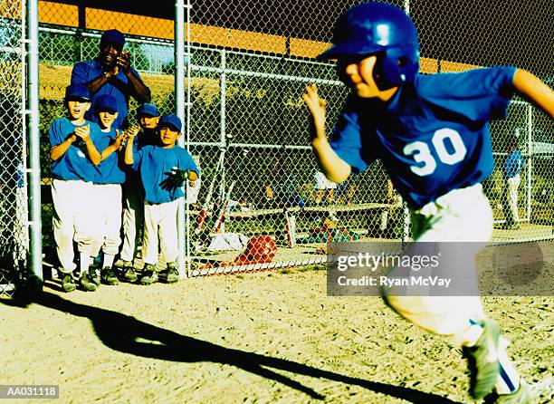 little league player running by cheering team - baseball strip stock-fotos und bilder