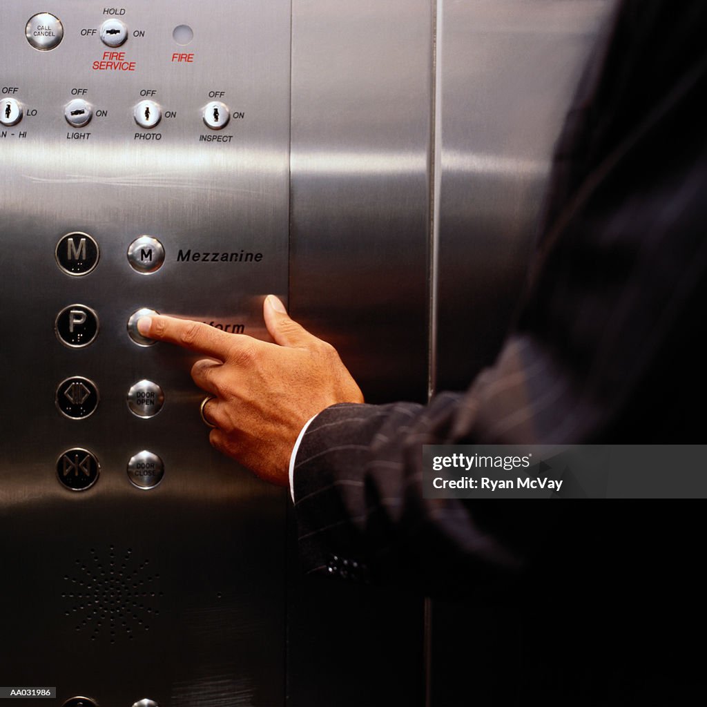 Man Pressing a Button in an Elevator