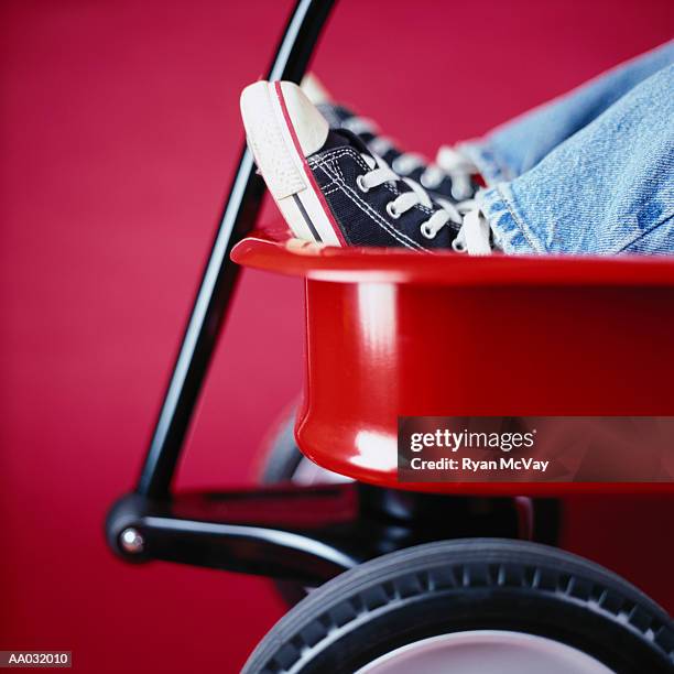 boy sitting in a red wagon - baseball cleats fotografías e imágenes de stock