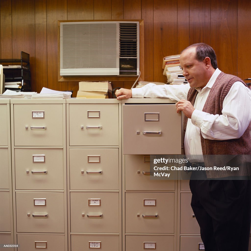 Businessman Looking in a Filing Cabinet