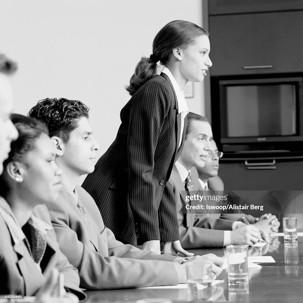 Businesswoman standing during meeting (B&W)