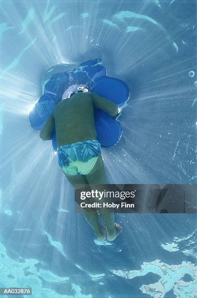 underwater view of child in swimming pool - speedo boy stock pictures, royalty-free photos & images