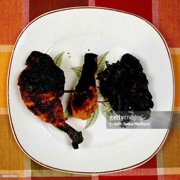 charred fowl on plate - burnt chicken stock pictures, royalty-free photos & images