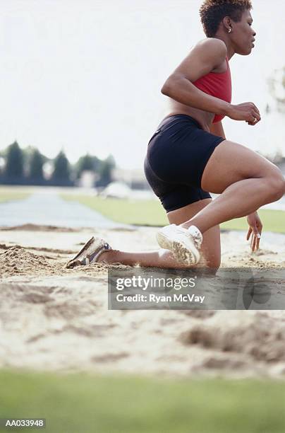 young woman performing the long jump - womens field event imagens e fotografias de stock