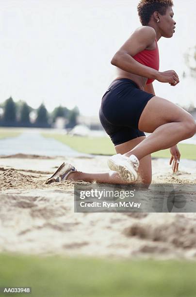 young woman performing the long jump - womens field event bildbanksfoton och bilder