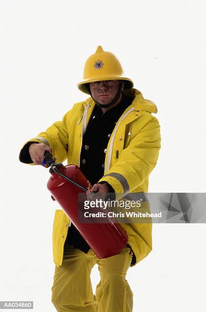 firefighter using a fire extinguisher - noodapparatuur stockfoto's en -beelden