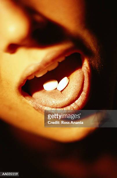 two aspirin on a woman's tongue - aspirin imagens e fotografias de stock