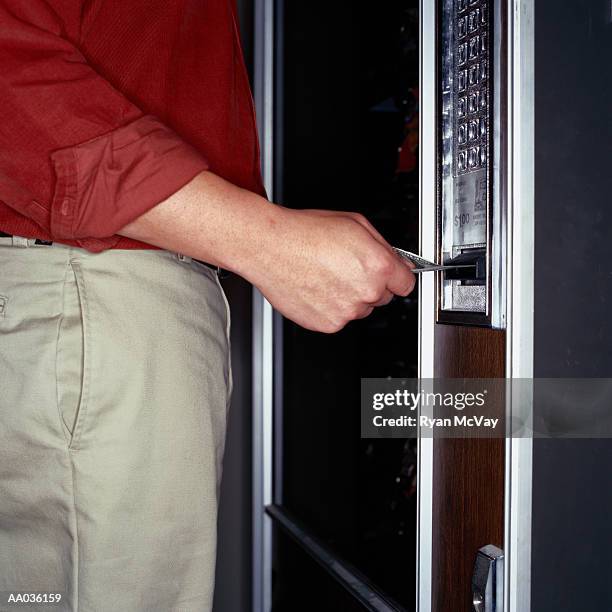 man inserting paper currency in a vending machine - office vending machine stock pictures, royalty-free photos & images