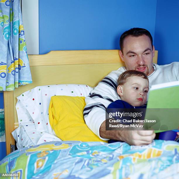 father reading to son - bedtime stories stock-fotos und bilder