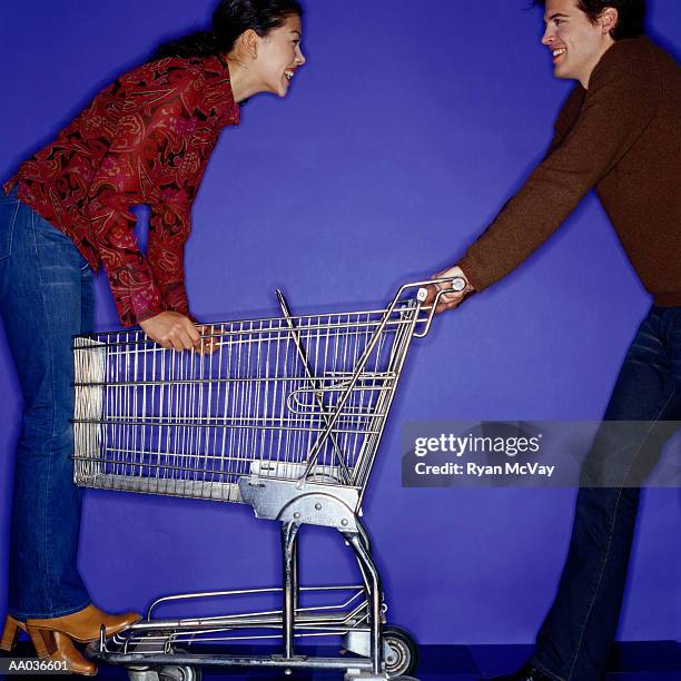 teenage girl (16-17) and young man playing with shopping cart - man pushing cart fun play stock pictures, royalty-free photos & images