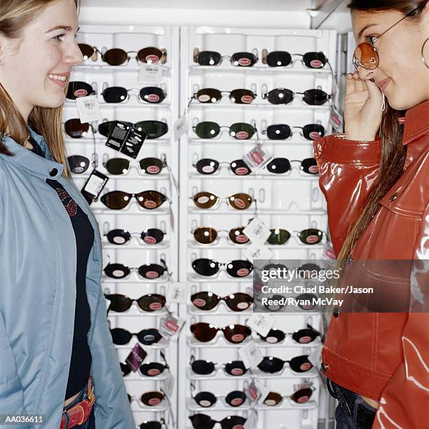 teenage girls shopping for sunglasses, side view - rose tinted glasses stock pictures, royalty-free photos & images