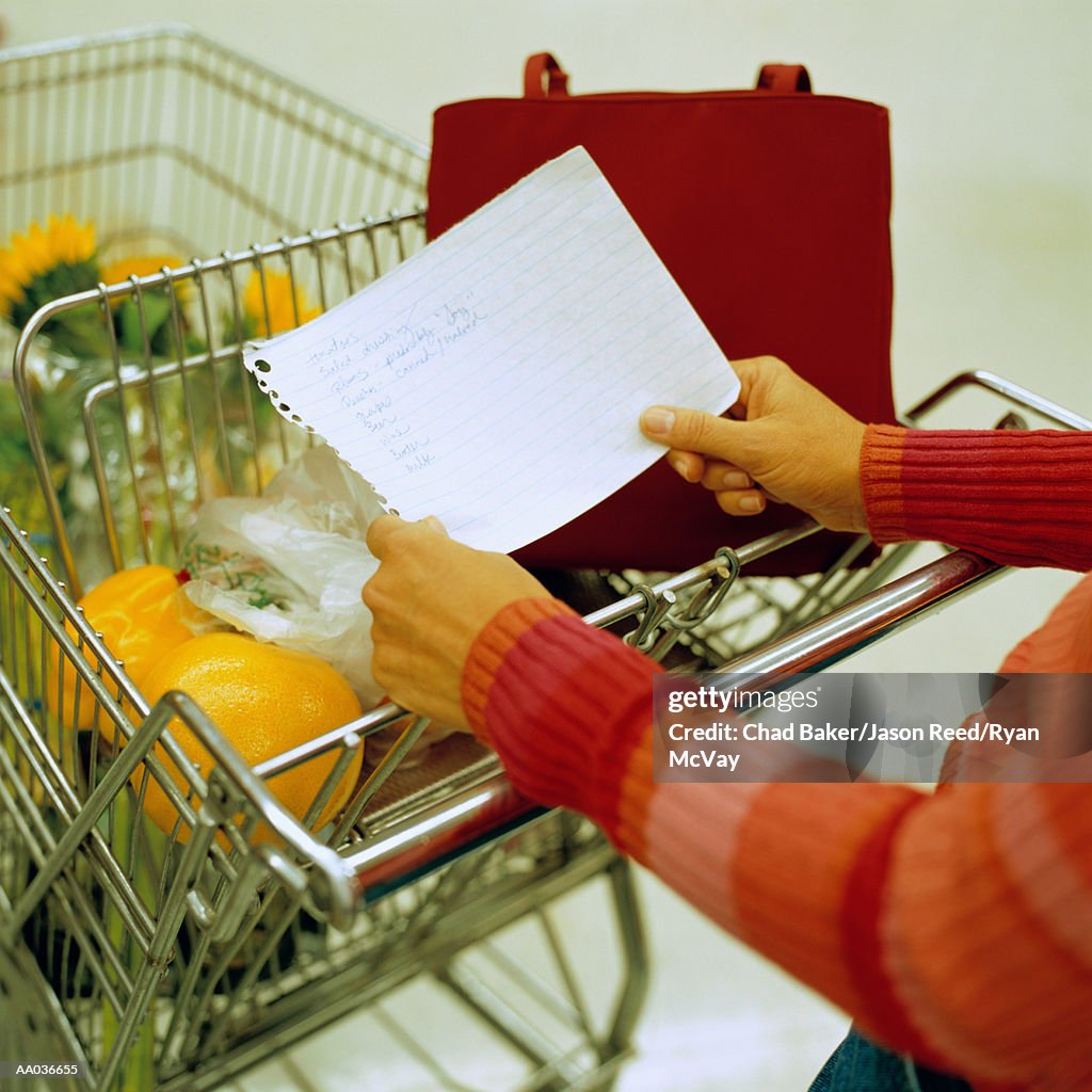 Woman reading her shopping list in the supermarket