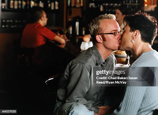 homosexual couple kissing in bar, side view - chad love stock pictures, royalty-free photos & images