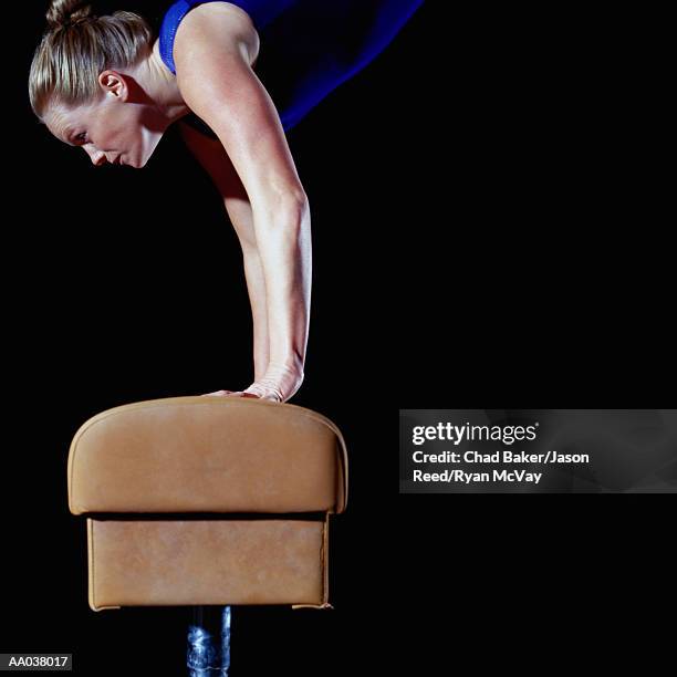 female gymnast balanced on vault, side view - gymnastics vault stock pictures, royalty-free photos & images