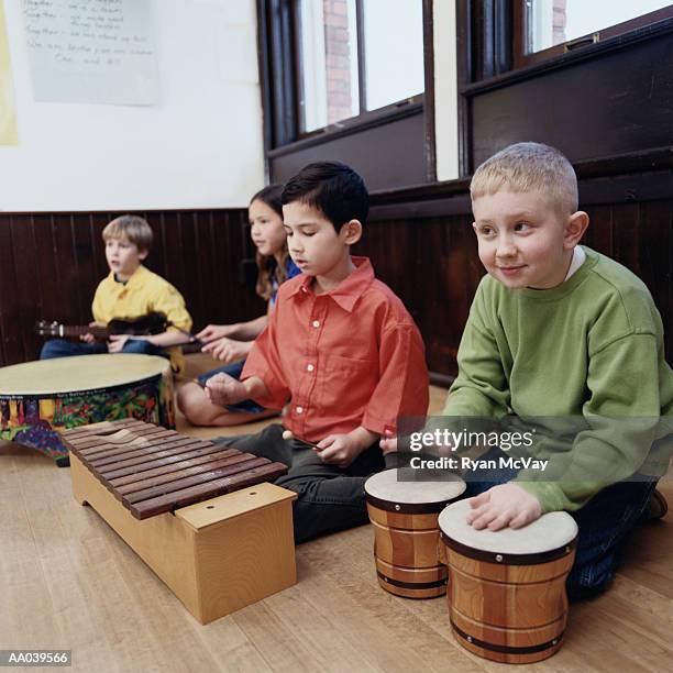group of students (8-10) playing musical instruments in classroom - xilofone imagens e fotografias de stock