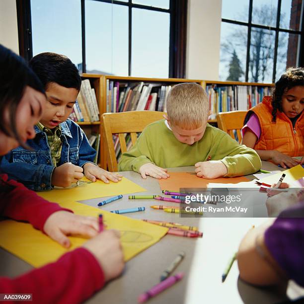 children (8-10) coloring with crayons at table in classroom - coloring stock pictures, royalty-free photos & images