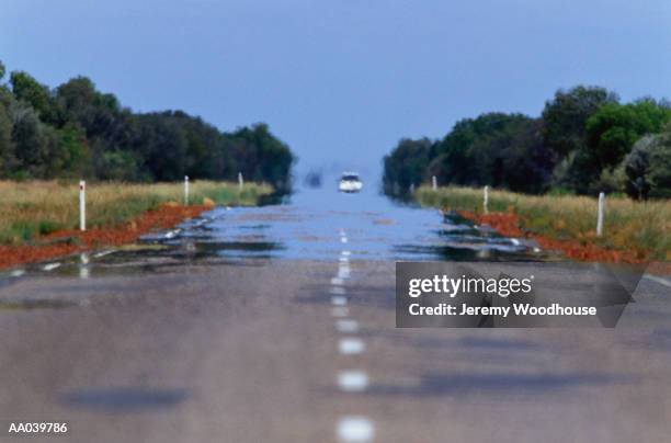 car on stuart highway and heat haze, australia - hot road photos et images de collection