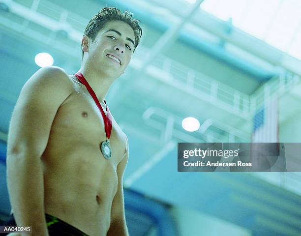 diver (16-18) with medal, low angle view (cross-processed) - speedo boy stock pictures, royalty-free photos & images