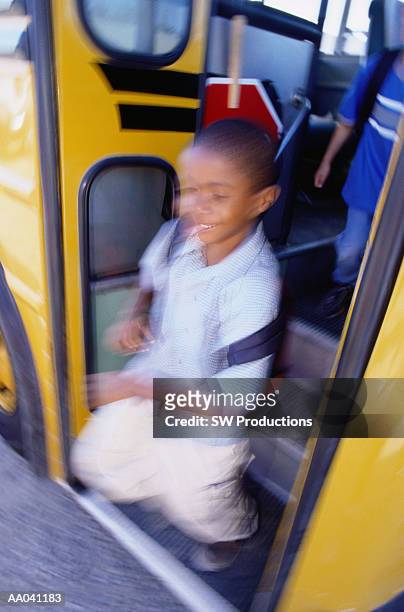boy (8-10) getting off school bus (blurred motion) - 10 off stock-fotos und bilder