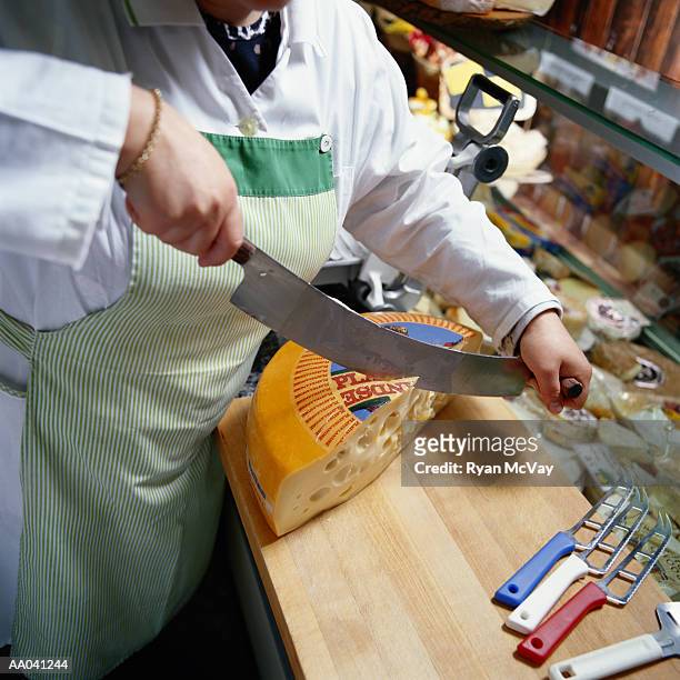 woman slicing cheese in a delicatessen - carvery stockfoto's en -beelden