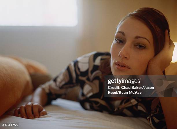 young woman lying on bed - reed bed stock pictures, royalty-free photos & images