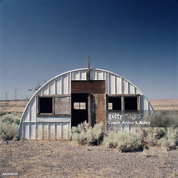 abandoned quonset hut in desert - quonset hut stock pictures, royalty-free photos & images