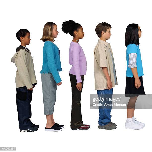 children (11-13) standing in line, side view - standing in line stock-fotos und bilder