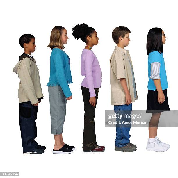 children (11-13) standing in line, side view - mensen op een rij stockfoto's en -beelden