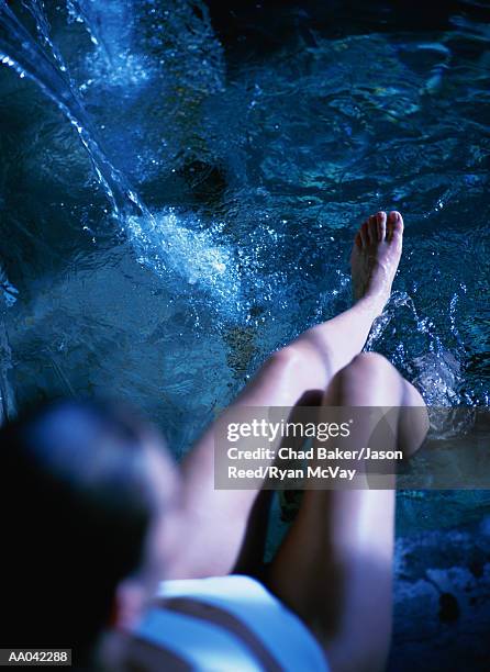 young woman splashing her legs in water, elevated view - balneotherapy stock pictures, royalty-free photos & images