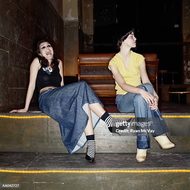 young women sitting in a nightclub - proceso cruzado fotografías e imágenes de stock