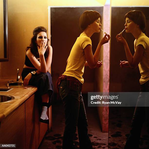 young women putting on make-up in nightclub bathroom - cross processed stock pictures, royalty-free photos & images