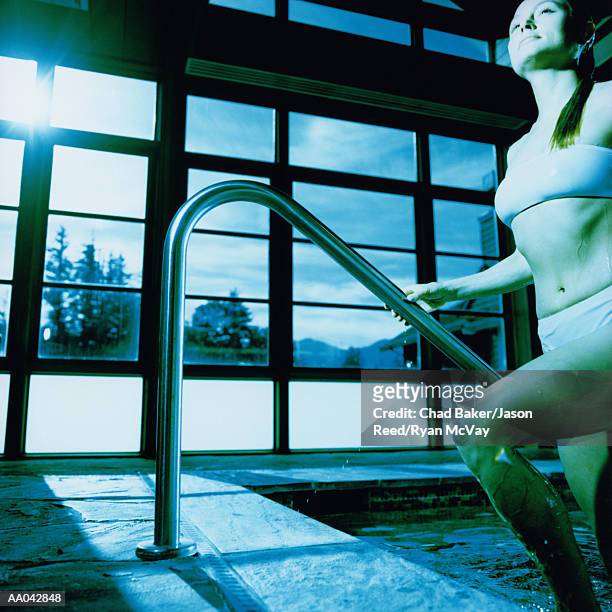 young woman stepping out of soaking pool at spa - supreme fiction stock pictures, royalty-free photos & images