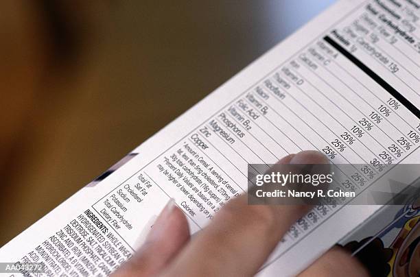 person reading ingredients on cereal box - cereal boxes stock pictures, royalty-free photos & images