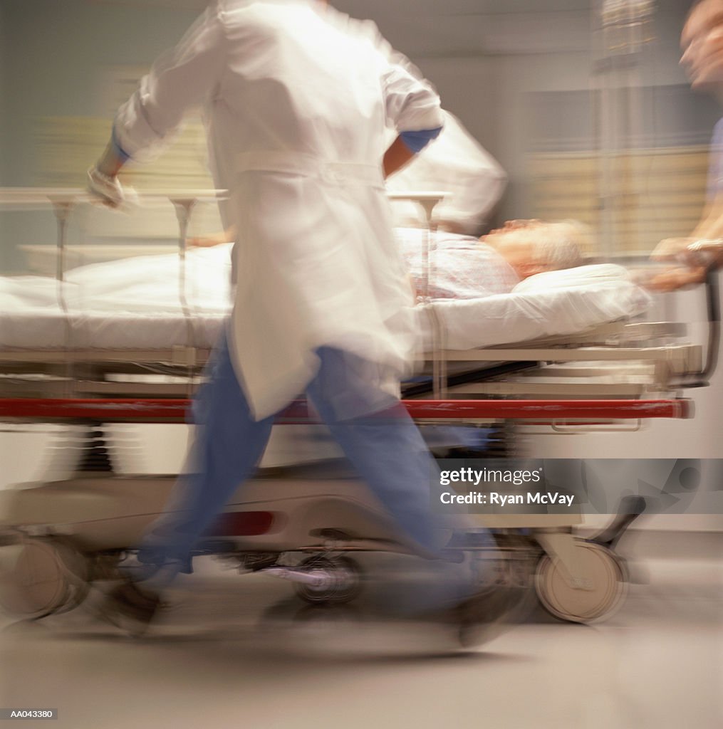 Doctors pushing patient on trolley (blurred motion)
