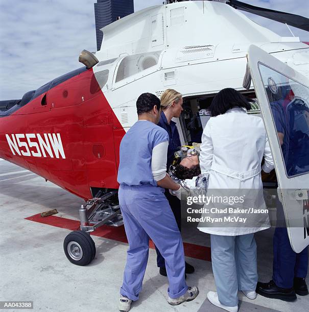 paramedics removing patient from medevac - elicottero-ambulanza foto e immagini stock