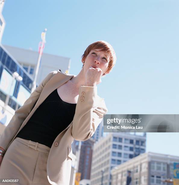 young businesswoman whistling for taxi on city street - monica askew stock pictures, royalty-free photos & images