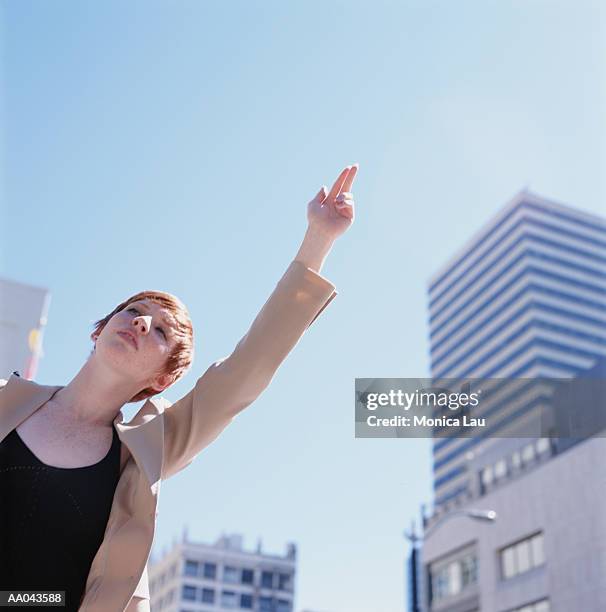 young businesswoman hailing taxi, low angle view - monica askew stock pictures, royalty-free photos & images