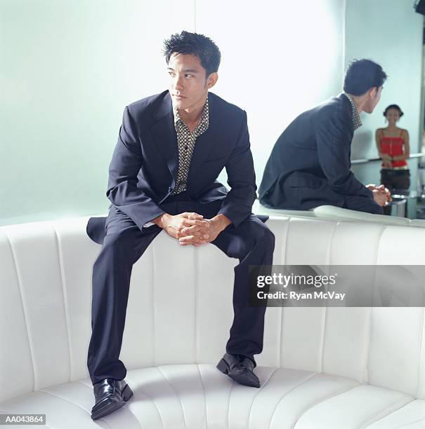 young man sitting on top of booth in bar, looking at young woman - woman sitting top man stock pictures, royalty-free photos & images