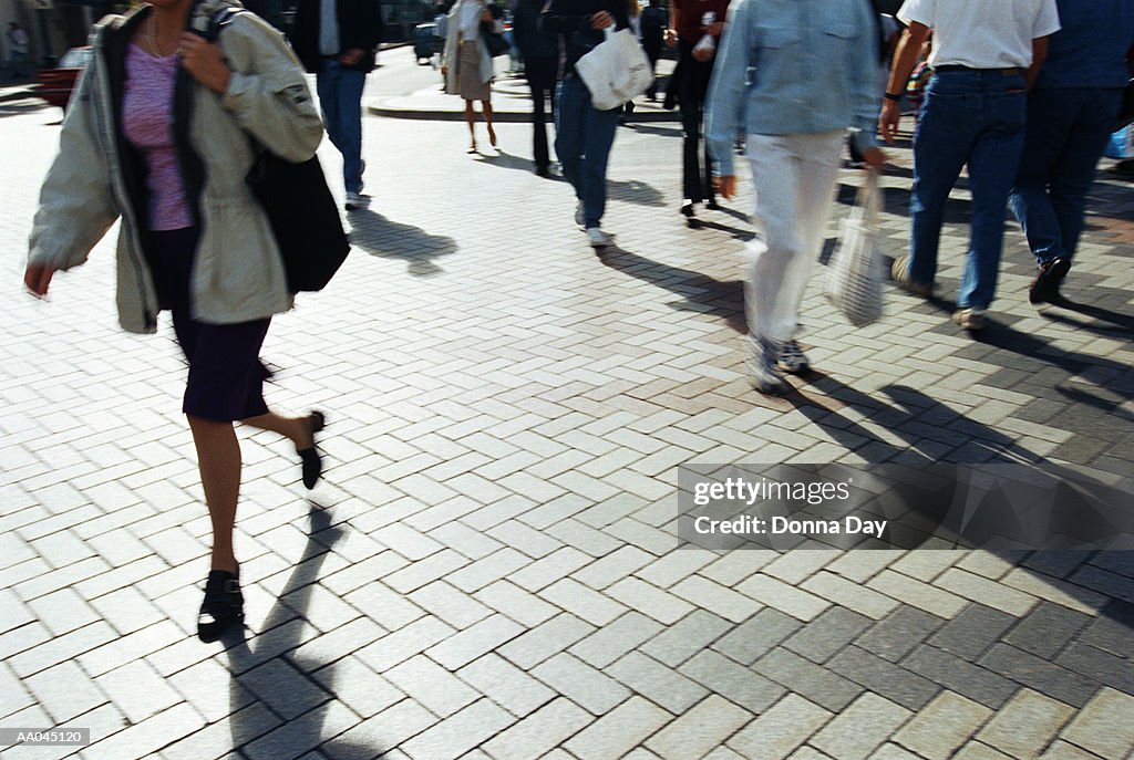 People crossing city street, mid section (blurred motion)