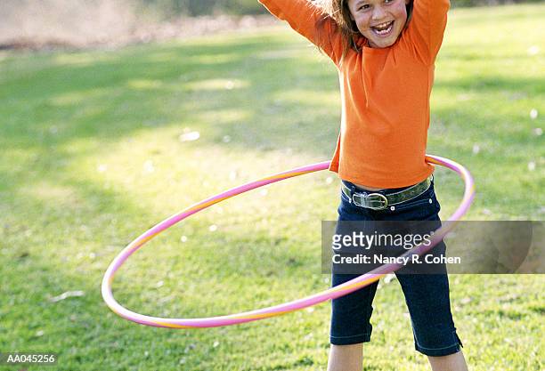 girl (7-9) playing plastic hoop - nancy green fotografías e imágenes de stock
