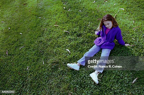 girl (7-9) sitting on lawn, elevated view - nancy green fotografías e imágenes de stock