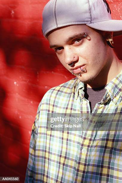 young man with facial piercings - male eyebrow piercing stock pictures, royalty-free photos & images