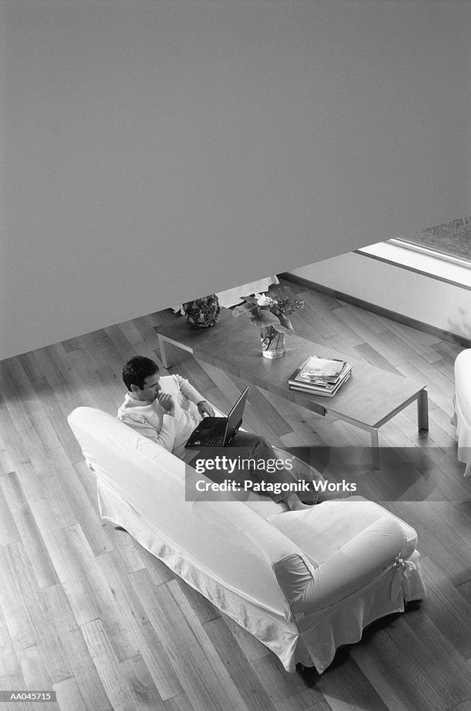 Man using laptop in living room