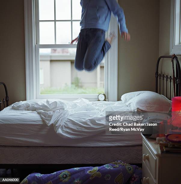 girl (10-12) jumping on bed, low section (blurred motion) - reed bed stock pictures, royalty-free photos & images